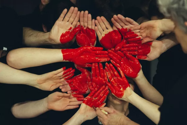 Many hands with a big painted heart. Photo: Tim Marshall, Unsplash.